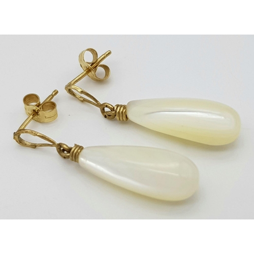 703 - A pair of 9ct gold drop earrings featuring stone pendants. Total weight: 2g , 2.6cm drop length.