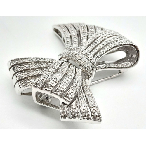 470 - A 14K White Gold and Diamond Bow Brooch. A 1.5ctw (approx) of diamond cluster excellence. 13.25g tot... 