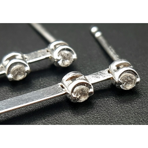 1373 - A Pair of 18K White Gold Diamond Bar Drop Earrings. Three diamonds on each articulated bar. 3.5cm dr... 