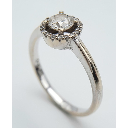 1254 - An 18K White Gold Diamond Ring. Round cut centre stone with a diamond halo. Size M, 2.93g total weig... 