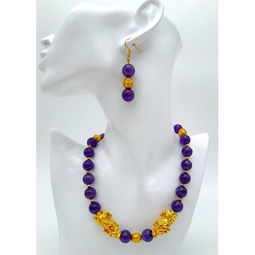 147 - A Chinese, amethyst necklace and earrings set with gold plated fu dogs and “good luck” charms. In a ... 