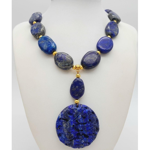 175 - A very substantial, lapis lazuli necklace with a highly detailed carved pendant with a naturalistic ... 