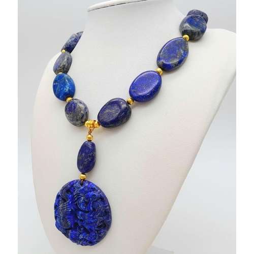 175 - A very substantial, lapis lazuli necklace with a highly detailed carved pendant with a naturalistic ... 