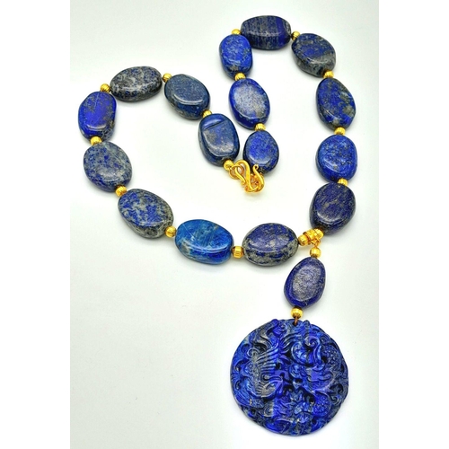 175 - A very substantial, lapis lazuli necklace with a highly detailed carved pendant with a naturalistic ... 