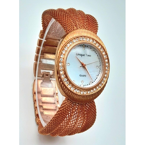 196 - A very feminine, rose gold plated, UNIQUE TIME ladies watch. Case 34 mm, bezel studded with cubic zi... 