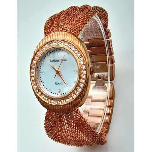 196 - A very feminine, rose gold plated, UNIQUE TIME ladies watch. Case 34 mm, bezel studded with cubic zi... 