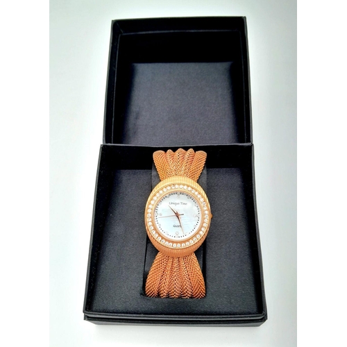 196 - A very feminine, rose gold plated, UNIQUE TIME ladies watch. Case 34 mm, bezel studded with cubic zi... 