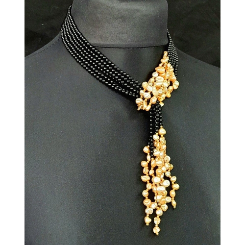 203 - A long, three strand, black onyx and cream coloured Keshi pearl necklace that can be worn in several... 