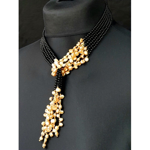 203 - A long, three strand, black onyx and cream coloured Keshi pearl necklace that can be worn in several... 