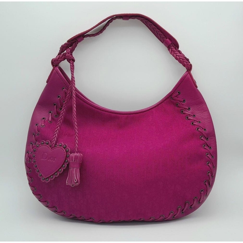 213 - A Dior Fuchsia Pink Hobo Bag. Leather exterior with silver-toned hardware, braided leather strap, an... 