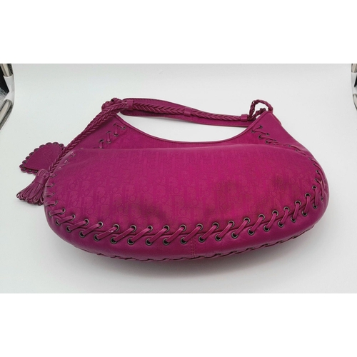 213 - A Dior Fuchsia Pink Hobo Bag. Leather exterior with silver-toned hardware, braided leather strap, an... 