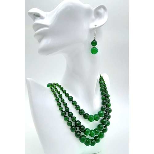 231 - An Oriental green jade necklace, with one to three strands and earrings set. Necklace Length: 50 cm,... 