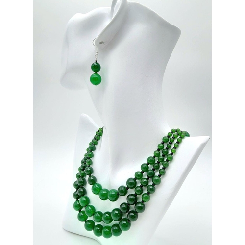 231 - An Oriental green jade necklace, with one to three strands and earrings set. Necklace Length: 50 cm,... 