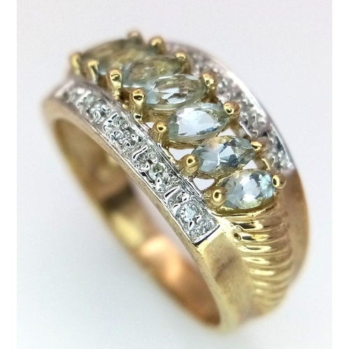 253 - A 9K Yellow Gold Aquamarine and Diamond Ring. Marquise shaped aqua between two rows of diamonds. Siz... 