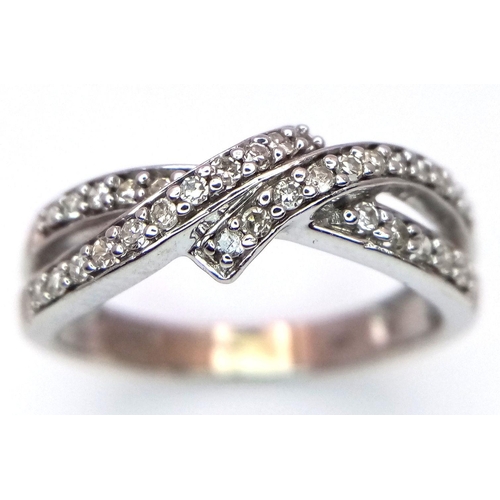 351 - A 9K White Gold Diamond Crossover Ring. 0.27ctw diamonds. Size N. 2.66g total weight.