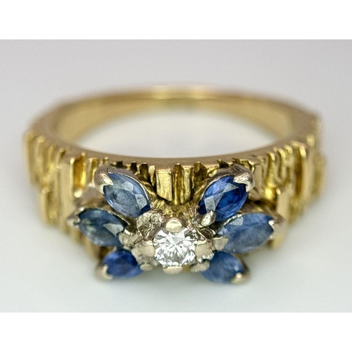 45 - An 18K Sapphire and Diamond 18k Gold Ring. Central diamond with a four petal sapphire surround. Size... 