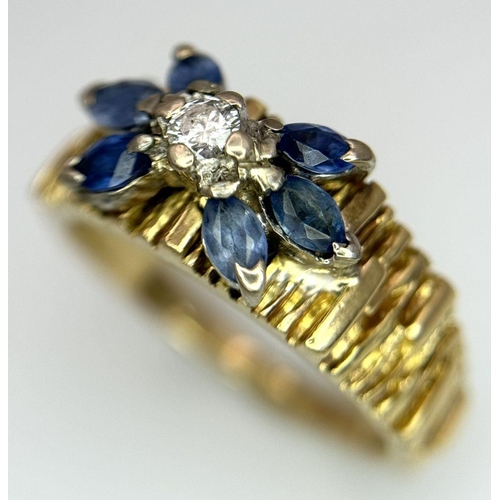 45 - An 18K Sapphire and Diamond 18k Gold Ring. Central diamond with a four petal sapphire surround. Size... 