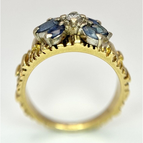 45 - An 18K Sapphire and Diamond 18k Gold Ring. Central diamond with a four petal sapphire surround. Size... 