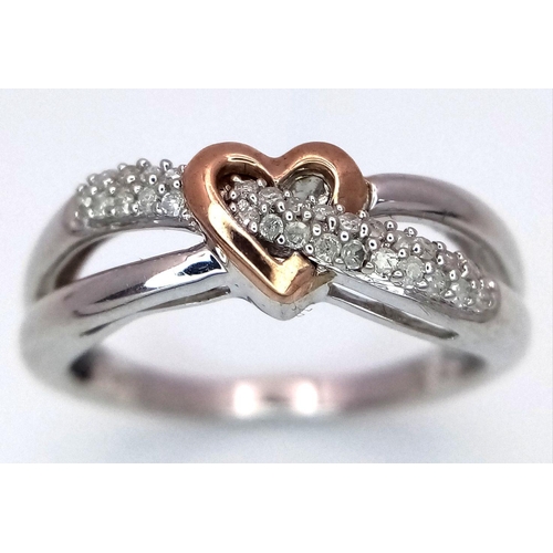 519 - A 9K White and Rose Gold Diamond Heart Crossover Ring. 0.10ctw diamonds. Size L. 2.6g total weight.