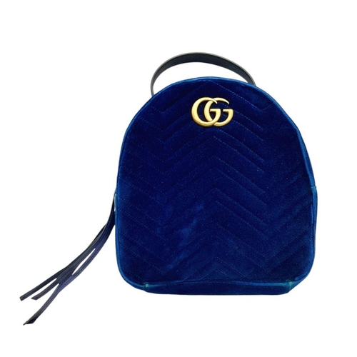 95 - A Gucci Marmont Blue Velvet Backpack. Gold tone hardware. Blue leather straps. Pink textile interior... 