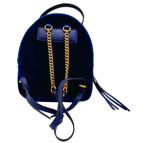 95 - A Gucci Marmont Blue Velvet Backpack. Gold tone hardware. Blue leather straps. Pink textile interior... 