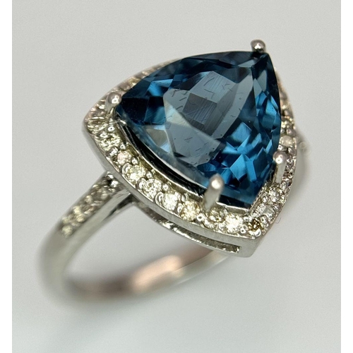 885 - A 2.5ct London Blue Topaz and Diamond Ring. Trillion cut with a  0.40ct Diamond Accents Surround. Se... 