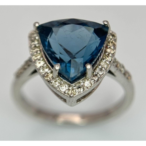 885 - A 2.5ct London Blue Topaz and Diamond Ring. Trillion cut with a  0.40ct Diamond Accents Surround. Se... 