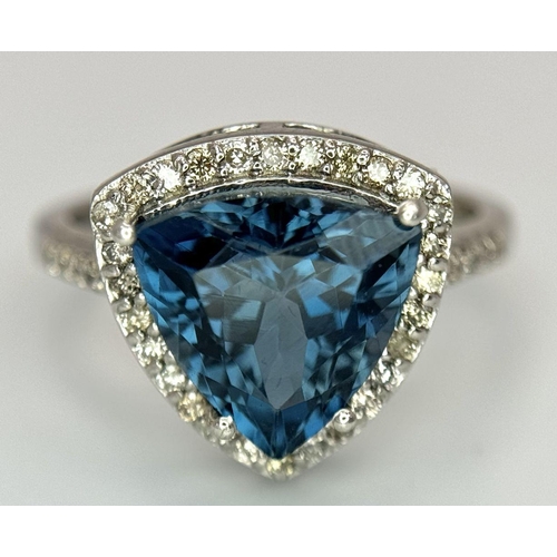 885 - A 2.5ct London Blue Topaz and Diamond Ring. Trillion cut with a  0.40ct Diamond Accents Surround. Se... 