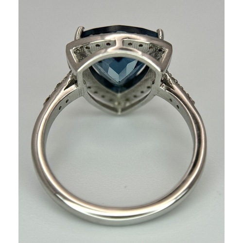 885 - A 2.5ct London Blue Topaz and Diamond Ring. Trillion cut with a  0.40ct Diamond Accents Surround. Se... 