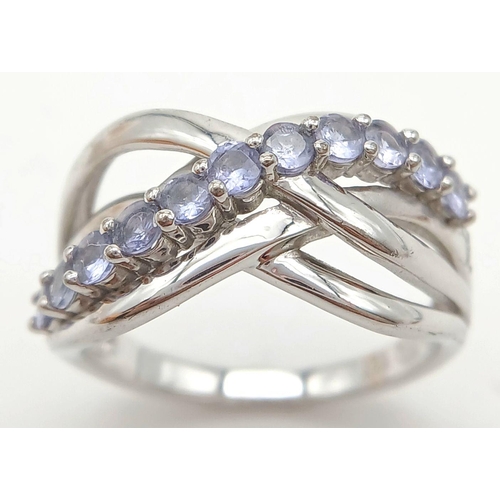 1427 - A Sterling Silver Tanzanite Set Crossover Ring Size P. The Ring measures 1.2cm Wide at the widest po... 