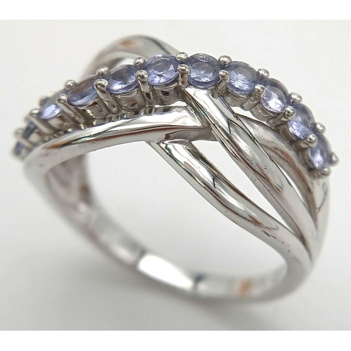 1427 - A Sterling Silver Tanzanite Set Crossover Ring Size P. The Ring measures 1.2cm Wide at the widest po... 