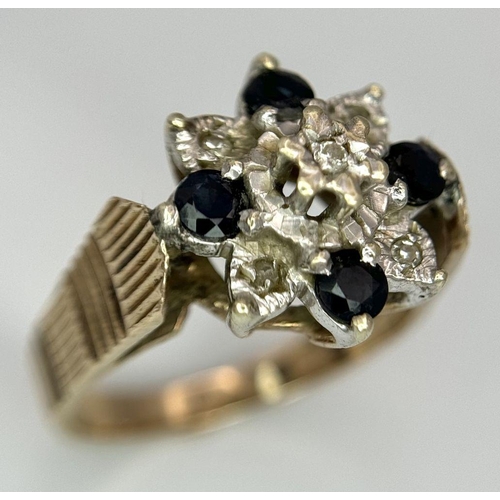 151 - A 9K YELLOW GOLD VINTAGE DIAMOND AND SAPPHIRE FLORAL FORM RING. RAISED REGAL SETTING. 5.4G. SIZE Q. ... 