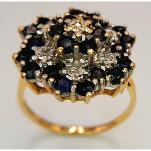 193 - AN ARTISTICALLY SET, 9K YELLOW GOLD DIAMOND AND SAPPHIRE LARGE CLUSTER RING. 5G. SIZE U. SC5050