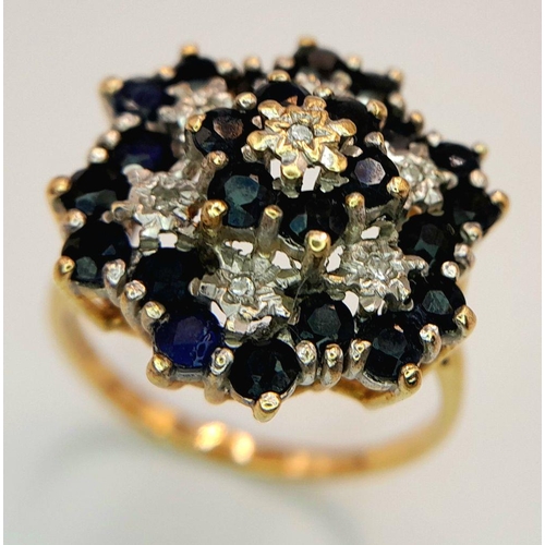 193 - AN ARTISTICALLY SET, 9K YELLOW GOLD DIAMOND AND SAPPHIRE LARGE CLUSTER RING. 5G. SIZE U. SC5050