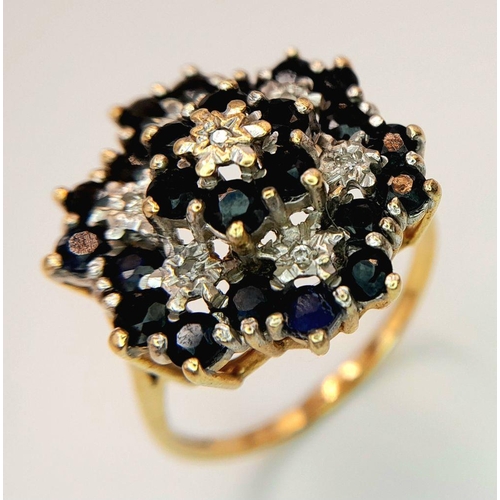 193 - AN ARTISTICALLY SET, 9K YELLOW GOLD DIAMOND AND SAPPHIRE LARGE CLUSTER RING. 5G. SIZE U. SC5050