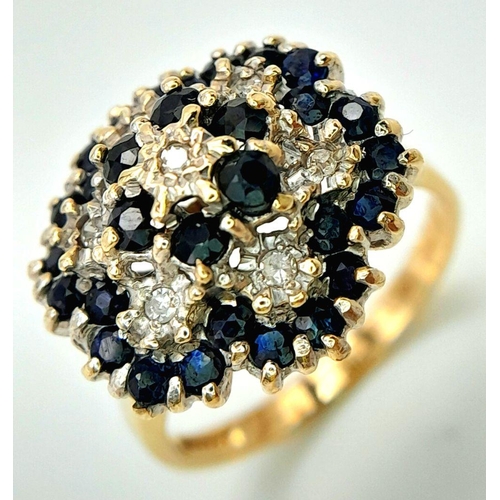 228 - A WONDERFUL 9K YELLOW GOLD DIAMOND AND SAPPHIRE CLUSTER RING. HEAD-TURNING FLORAL FORM DESIGN. 5.2G.... 