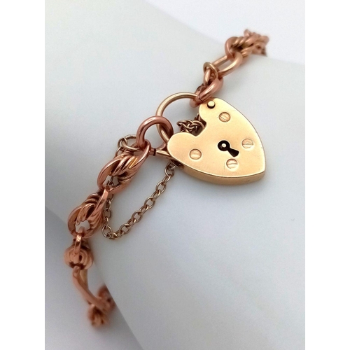 29 - A 9K rose Gold Twisted Bar and Knot Link Bracelet with a yellow gold Heart padlock Clasp. 18cm. 11.0... 