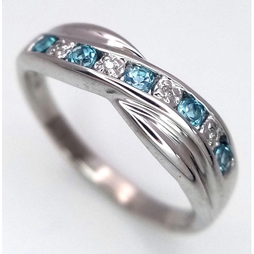 300 - A 9K WHITE GOLD DIAMOND AND TOPAZ TWIST RING. 2.5G. SIZE N. SC5047