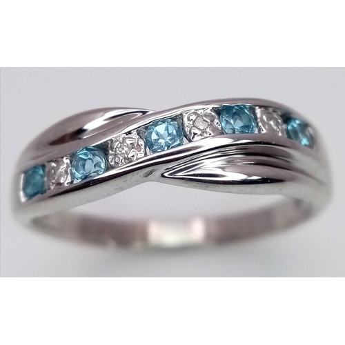 300 - A 9K WHITE GOLD DIAMOND AND TOPAZ TWIST RING. 2.5G. SIZE N. SC5047