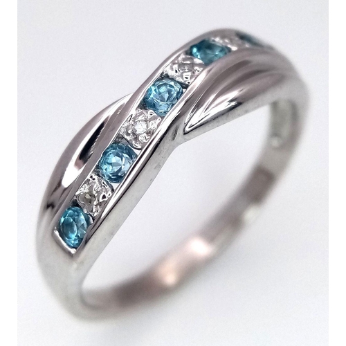 300 - A 9K WHITE GOLD DIAMOND AND TOPAZ TWIST RING. 2.5G. SIZE N. SC5047