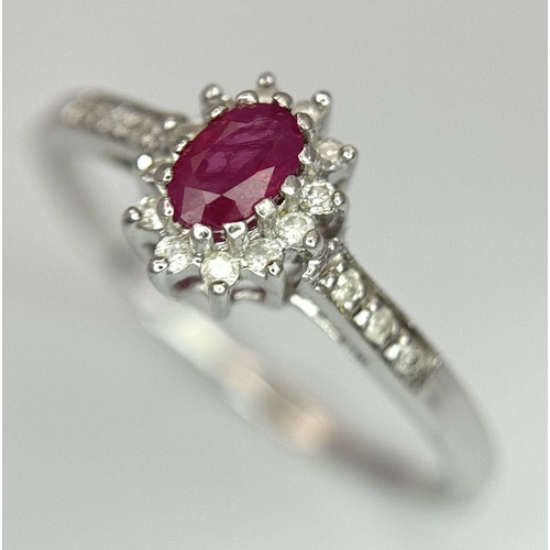 432 - A 9K WHITE GOLD DIAMOND AND RUBY RING. 2G. SIZE T. SC5034