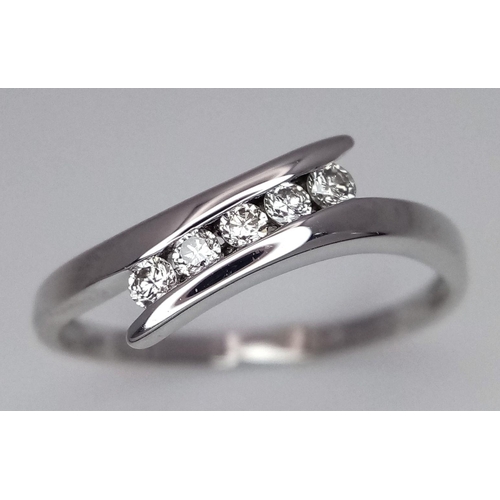 529 - A 9K WHITE GOLD DIAMOND SET TWIST RING. 0.15CT. 1.9G. SIZE P. SC5011