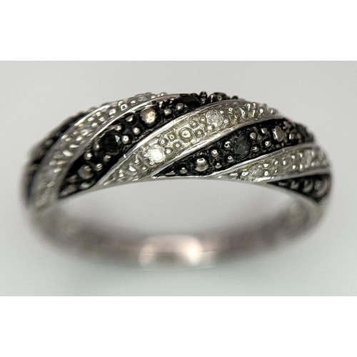 691 - A 9K WHITE GOLD, BLACK AND WHITE DIAMOND RING. 2.3G. SIZE O. SC2020