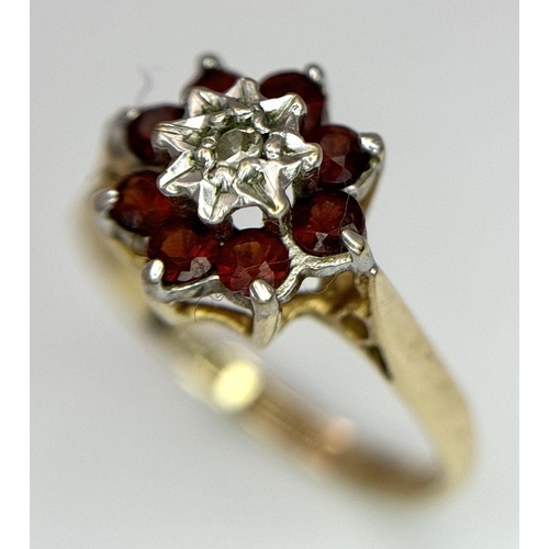 726 - A 9K YELLOW GOLD DIAMOND AND RED STONE RING - 1.9G. SIZE L 1/2. SC5036