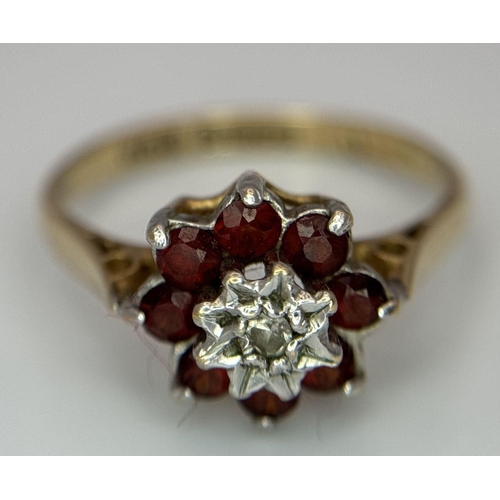 726 - A 9K YELLOW GOLD DIAMOND AND RED STONE RING - 1.9G. SIZE L 1/2. SC5036