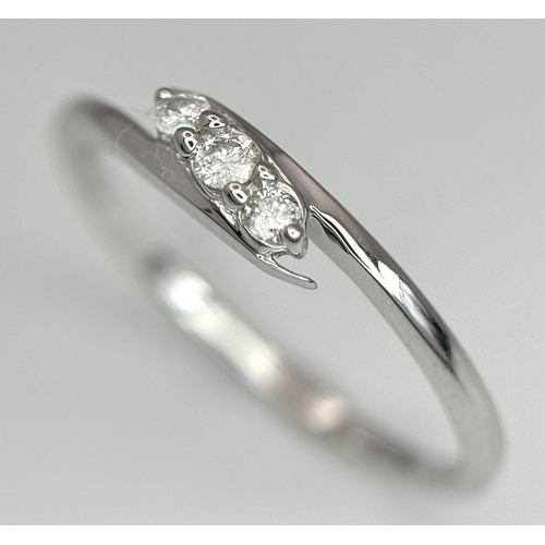 740 - A 9K WHITE GOLD DIAMOND SET THREE STONE TWIST RING. 1.5G. SIZE P. 8800