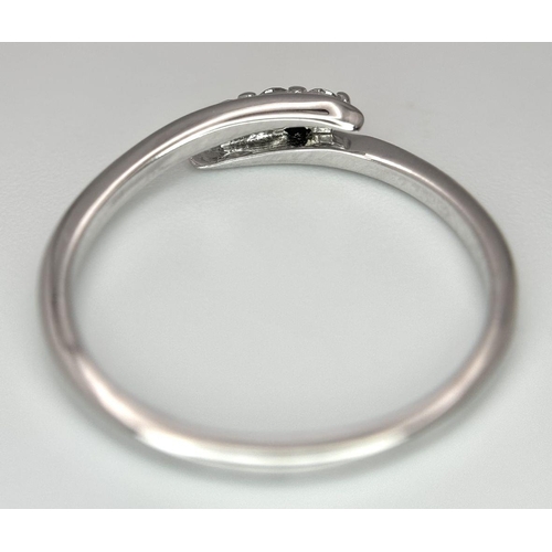 740 - A 9K WHITE GOLD DIAMOND SET THREE STONE TWIST RING. 1.5G. SIZE P. 8800