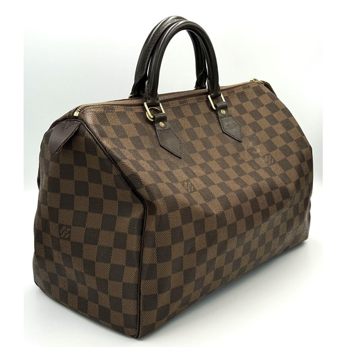 88 - A Louis Vuitton Speedy Damier Bag. Brown checked LV coated canvas exterior. Gold tone furniture. Red... 