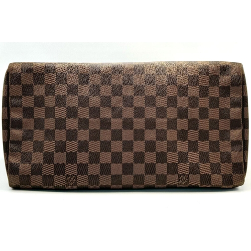 88 - A Louis Vuitton Speedy Damier Bag. Brown checked LV coated canvas exterior. Gold tone furniture. Red... 