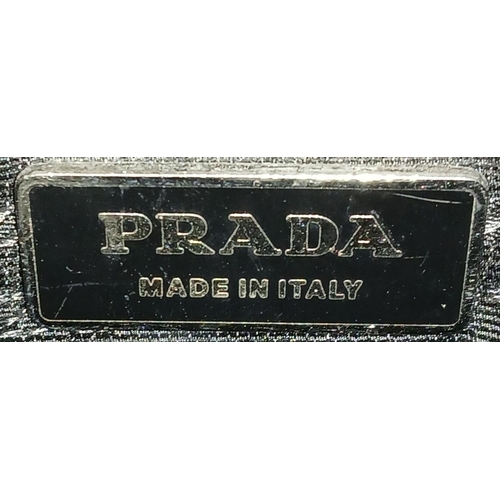 1174 - A Prada Black Textile Hand/Shoulder bag. Black leather trim and handles. Removable shoulder strap. T... 